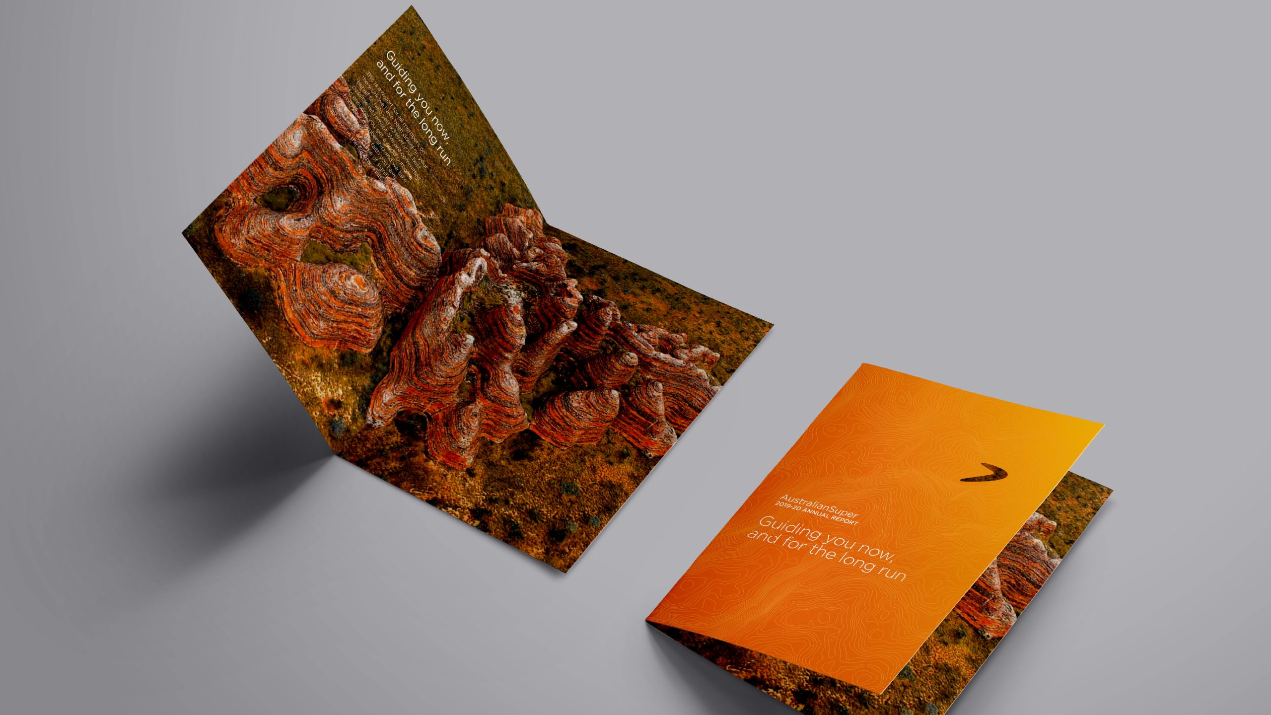 A flat lay image of the AustralianSuper 2019/2020 Annual Report. Includes aerial imagery of the Kimberley in Western Australia overlayed with topographic line work designed by Helium Design Melbourne.